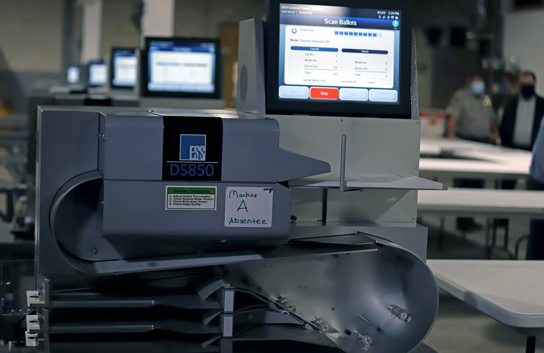 Photograph of a row of ballot scanning machines.