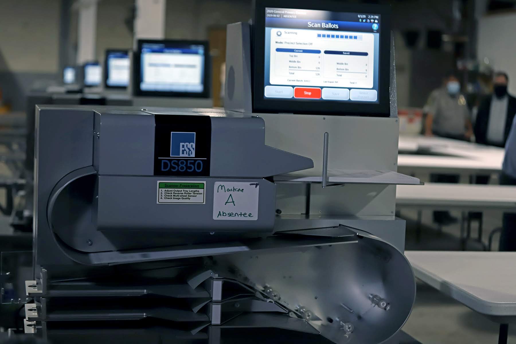 Photograph of a row of ballot scanning machines.